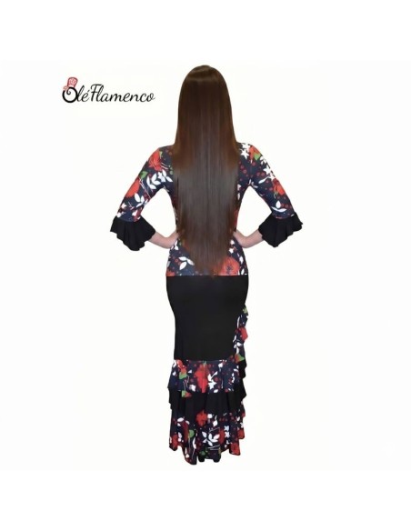 Vista posterior del conjunto de flamenca entallado con estampado de flores y falda técnica de ensayo.