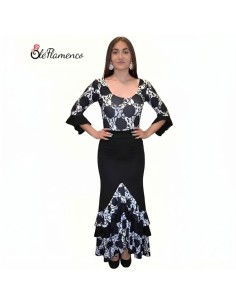 Bailaora con conjunto de flamenco de lunares grandes frontales, cuerpo entallado y falda con volantes en pico.