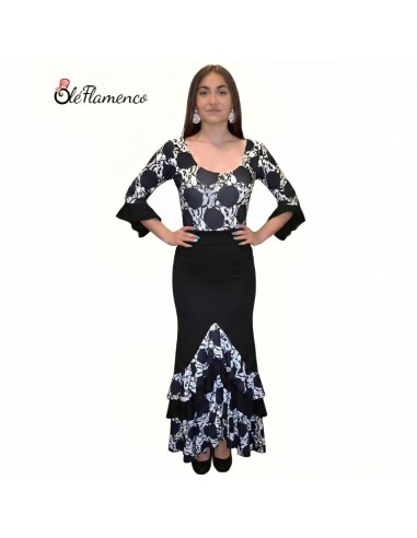 Bailaora con conjunto de flamenco de lunares grandes frontales, cuerpo entallado y falda con volantes en pico.