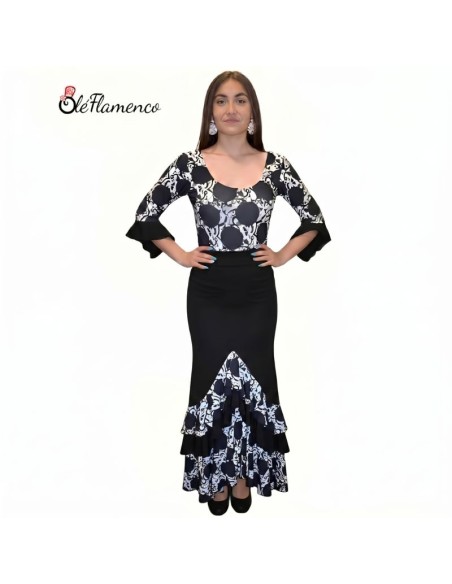 Bailaora con conjunto de flamenco de lunares grandes frontales, cuerpo entallado y falda con volantes en pico.
